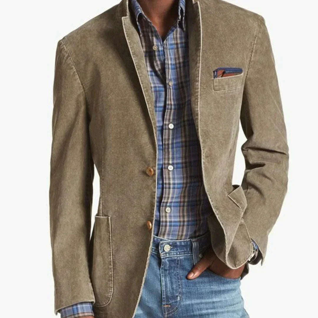 Un homme portant un blazer en velours côtelé beige avec des boutons en bois, associé à une chemise à carreaux bleus et blancs, et un pantalon en denim, créant un look élégant et décontracté.