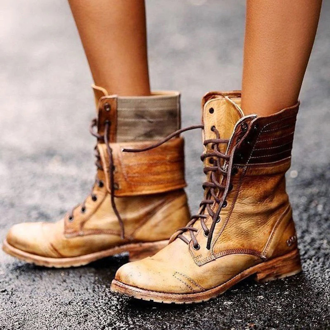 Bottines à lacets en cuir vintage pour femme, couleur beige patinée, au design rustique et élégant. Les chaussures présentent une semelle en caoutchouc robuste, un laçage avant ajustable et une texture vieillie pour un effet authentique. Portées sur une surface mouillée, elles mettent en valeur un style à la fois décontracté et raffiné, idéal pour les journées d’automne et d’hiver.