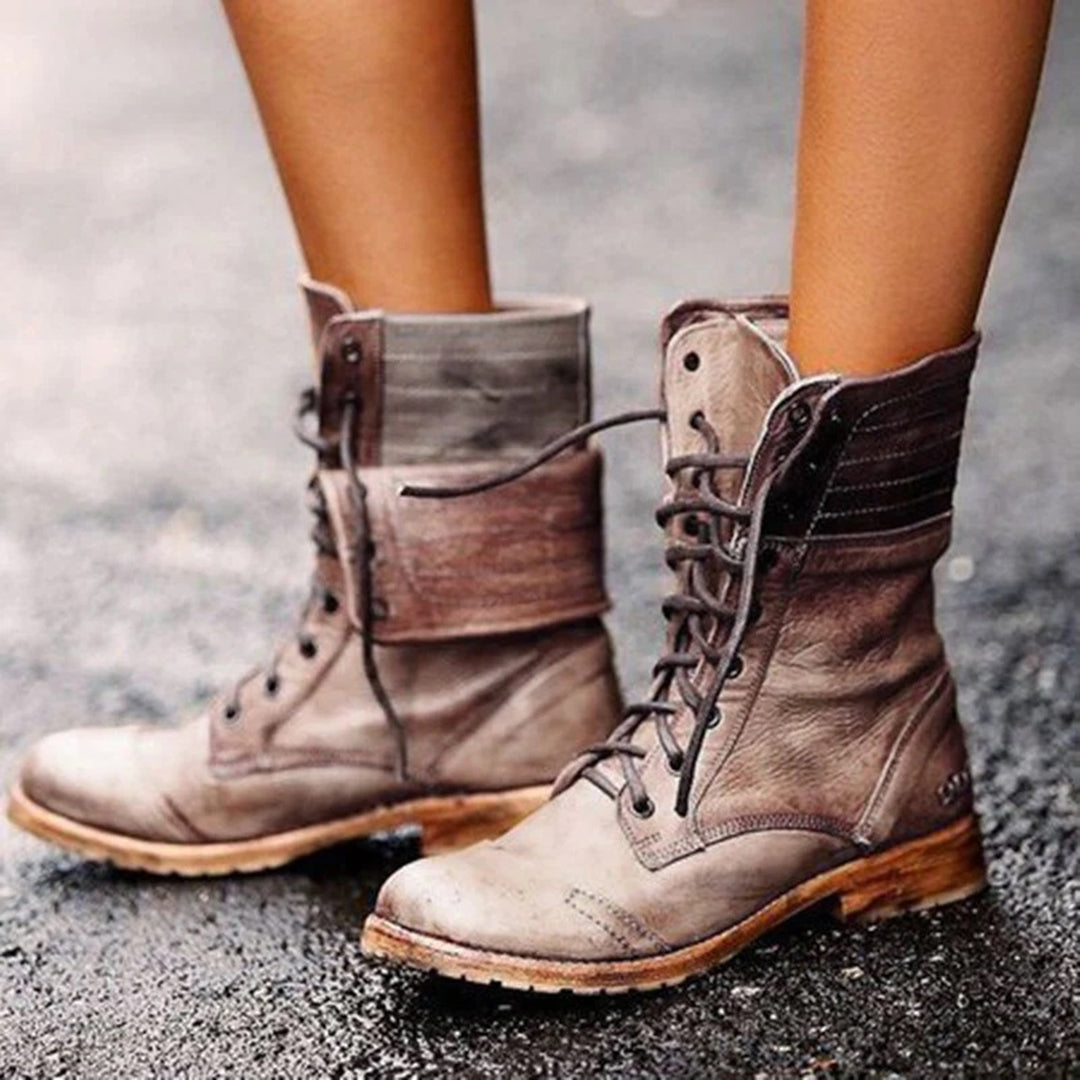 Bottes montantes pour femme en cuir vieilli marron clair, avec lacets sur le devant et revers souple. Leur semelle en bois offre une touche rustique et décontractée. Le style vintage et robuste est parfait pour compléter un look d’automne ou de mi-saison.