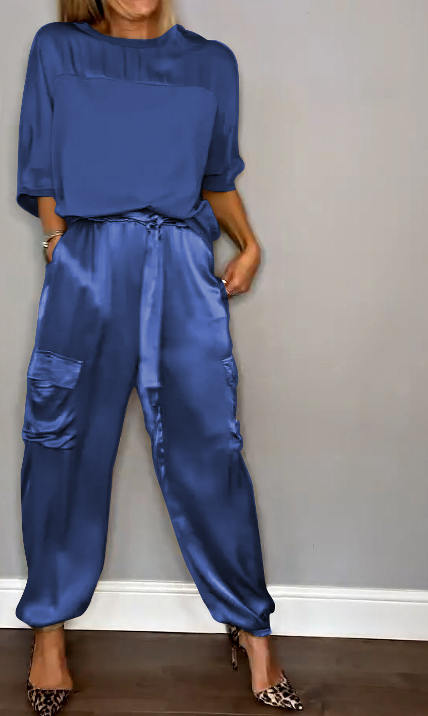 Une tenue chic composée d'un haut bleu satinée et d'un pantalon fluide à taille élastique avec des poches, porté avec des escarpins à motif léopard.