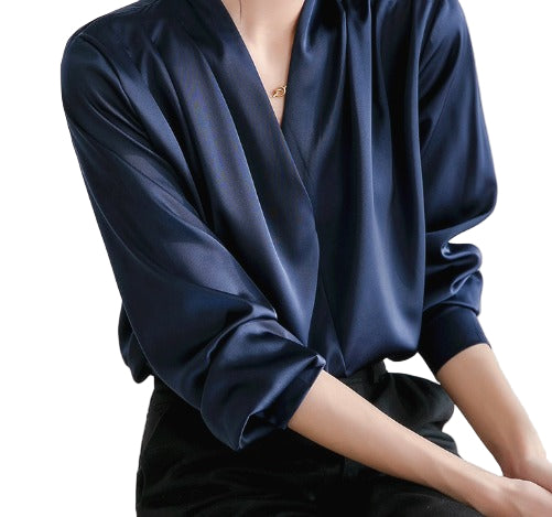 Blouse élégante à manches bouffantes et décolleté en V, portée par une femme avec un pantalon noir, offrant un look sophistiqué et raffiné.