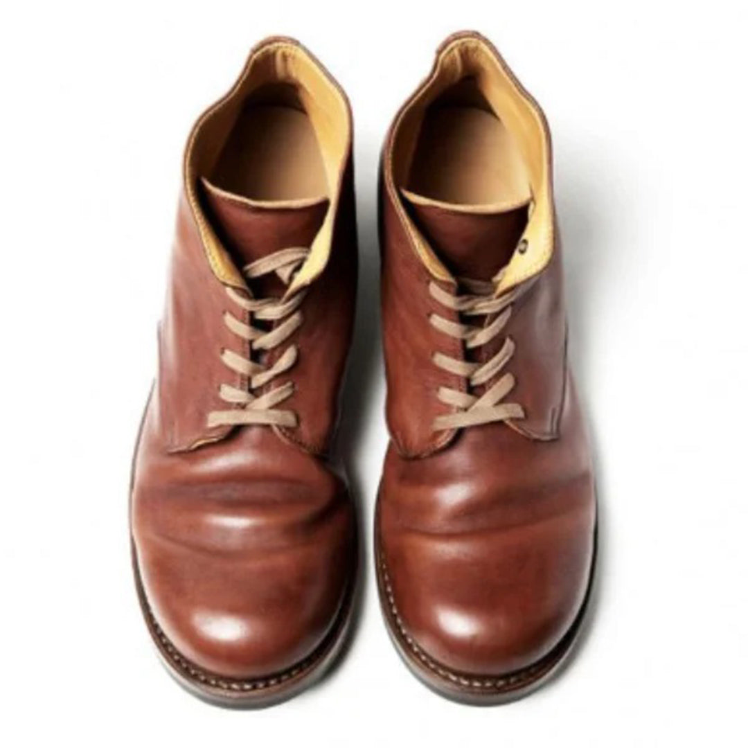 Paire de bottes en cuir marron pour homme, au design classique et élégant. Les chaussures présentent une finition lisse et brillante avec des lacets beiges et un intérieur beige clair. Leur semelle robuste assure durabilité et confort, idéale pour un style intemporel et professionnel.