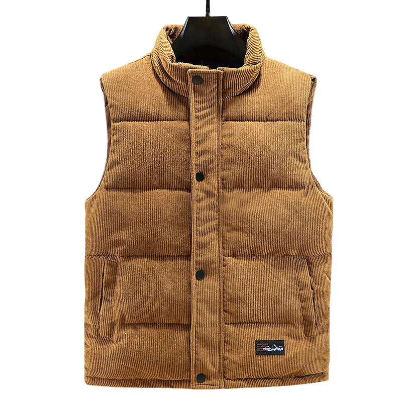 Gilet matelassé en velours côtelé marron pour homme, fermeture à boutons-pression et poches latérales discrètes. Son tissu texturé apporte une touche d'élégance et de chaleur, idéal pour un style automne/hiver moderne. Ce modèle sans manches allie confort, style et raffinement pour un look urbain décontracté.