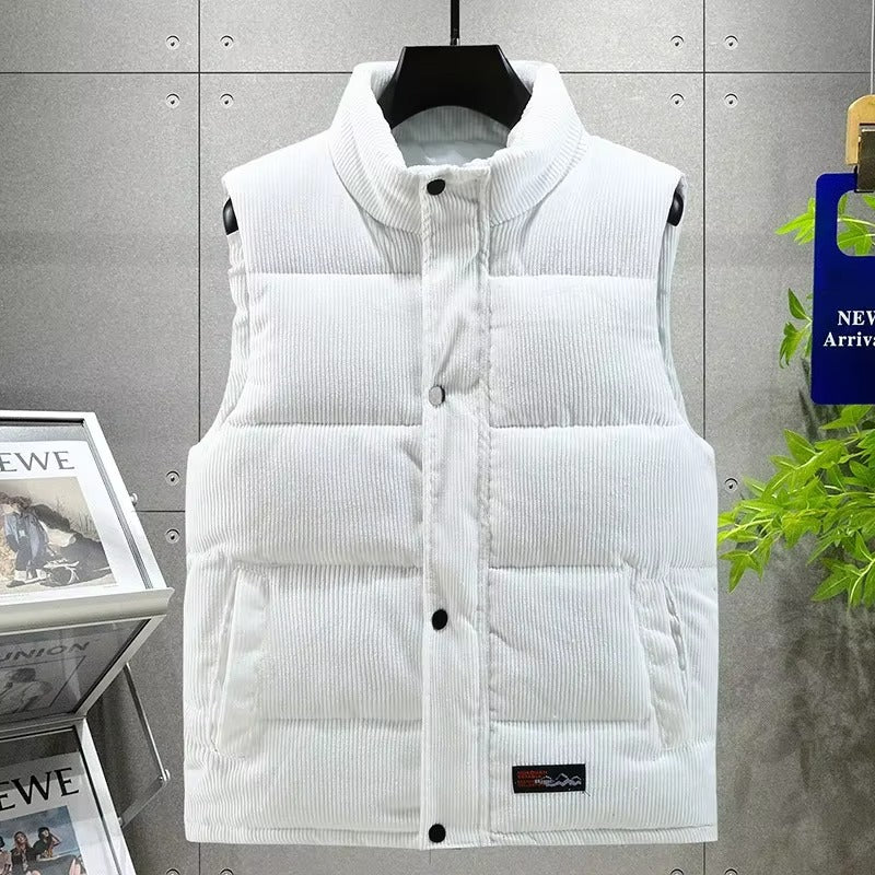 Gilet matelassé pour homme en velours côtelé blanc, doté d’une fermeture à boutons-pression et de poches latérales pratiques. Le tissu côtelé apporte une texture raffinée et moderne, idéale pour un style d’hiver élégant et minimaliste. Ce vêtement sans manches combine confort, chaleur et sophistication pour un look urbain intemporel.