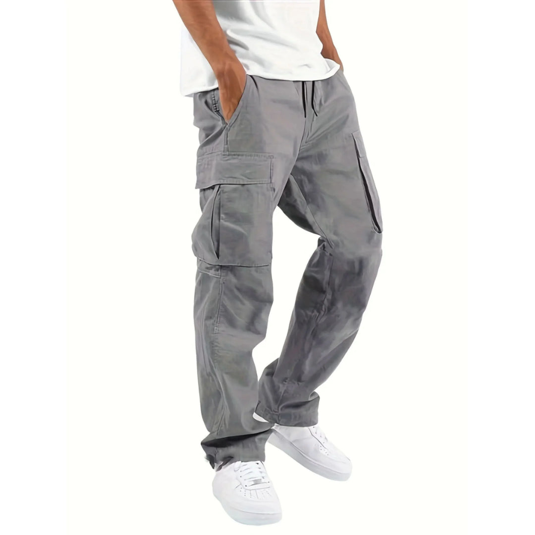 Pantalon cargo pour homme Adrienn, moderne et pratique, de couleur grise. Ce modèle avec des poches latérales et une coupe décontractée est parfait pour un style urbain et fonctionnel, adapté à un usage quotidien.