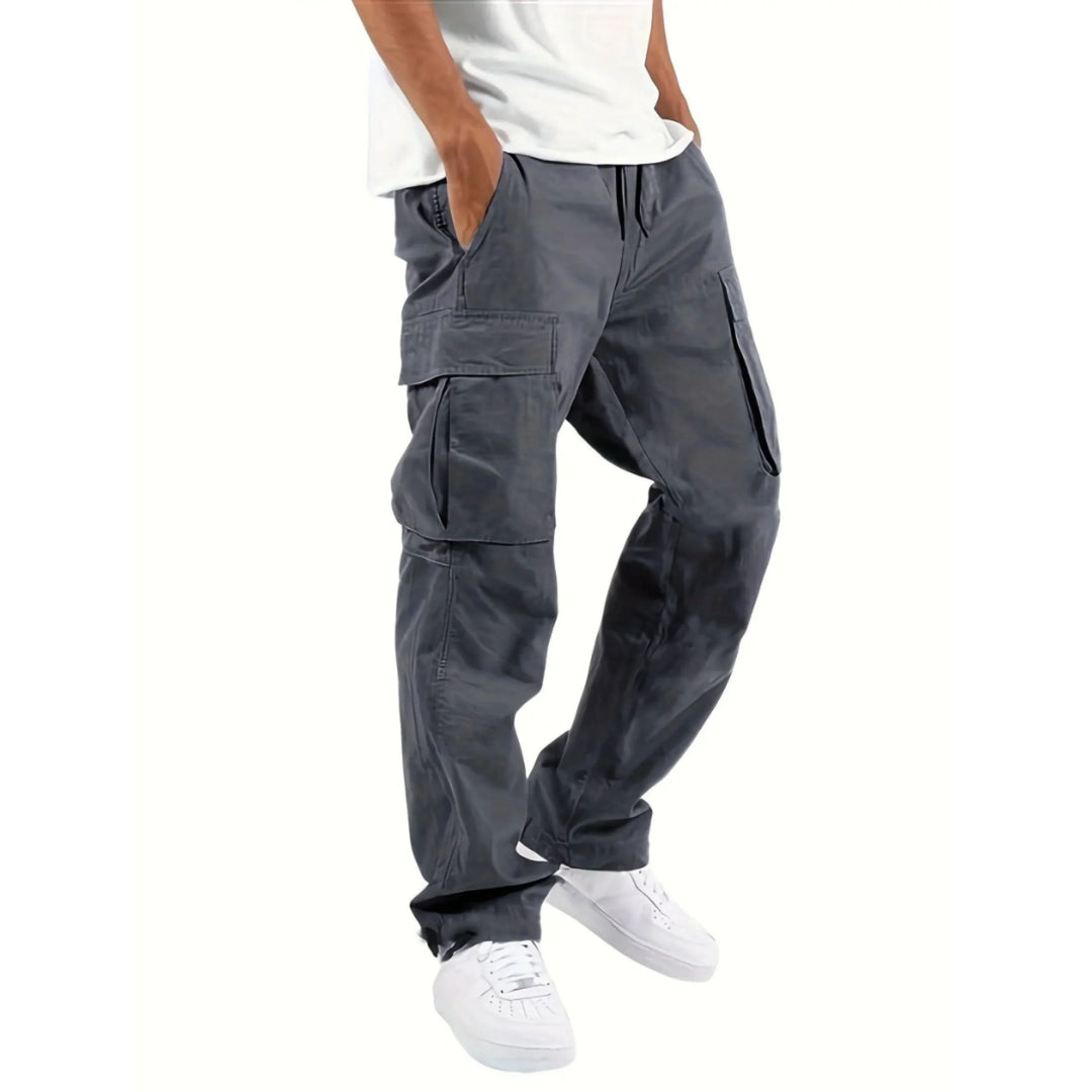 Pantalon cargo moderne pour homme Adrienn, de couleur grise, avec poches latérales pratiques. Idéal pour un look décontracté et stylé, à la fois confortable et fonctionnel, parfait pour les activités quotidiennes.
