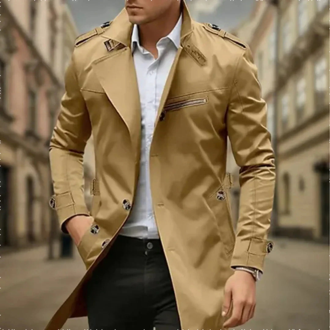 Trench-coat imperméable beige pour homme, avec des détails modernes comme des boutons métalliques et une fermeture éclair latérale. Parfait pour un look élégant et pratique lors des journées pluvieuses, offrant une coupe stylée et intemporelle.