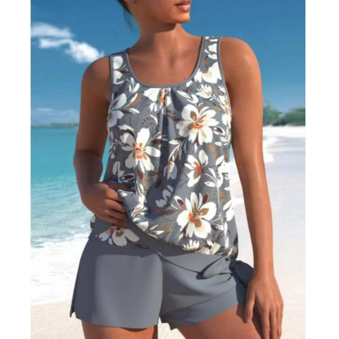 Le tankini Angélique pour femme, au design moderne et élégant, avec un haut à imprimé floral dans des tons gris et blancs. Il est accompagné d'un short assorti, idéal pour profiter des journées ensoleillées à la plage ou à la piscine.