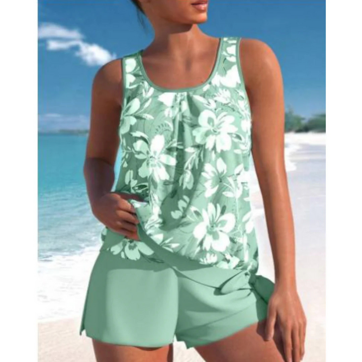 Le tankini Angélique pour femme, avec un joli imprimé floral blanc sur fond vert, accompagné d'un short assorti. Ce modèle tendance est parfait pour des journées estivales à la plage ou à la piscine, alliant confort et style.