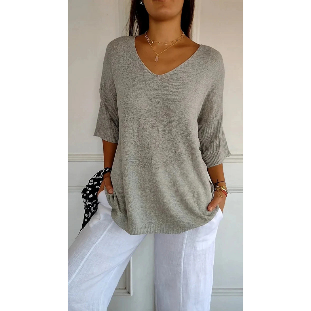 Le top en tricot Annabelle pour femme, au design moderne et raffiné, dans une teinte gris clair élégante. Ce modèle à col en V et manches 3/4 offre une coupe décontractée et chic, idéal pour une tenue à la fois confortable et stylée, à porter avec un pantalon léger ou un jean.