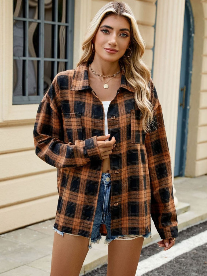 Femme portant une chemise longue à carreaux orange et noir, un crop top blanc et un short en jean, créant un look décontracté et moderne.