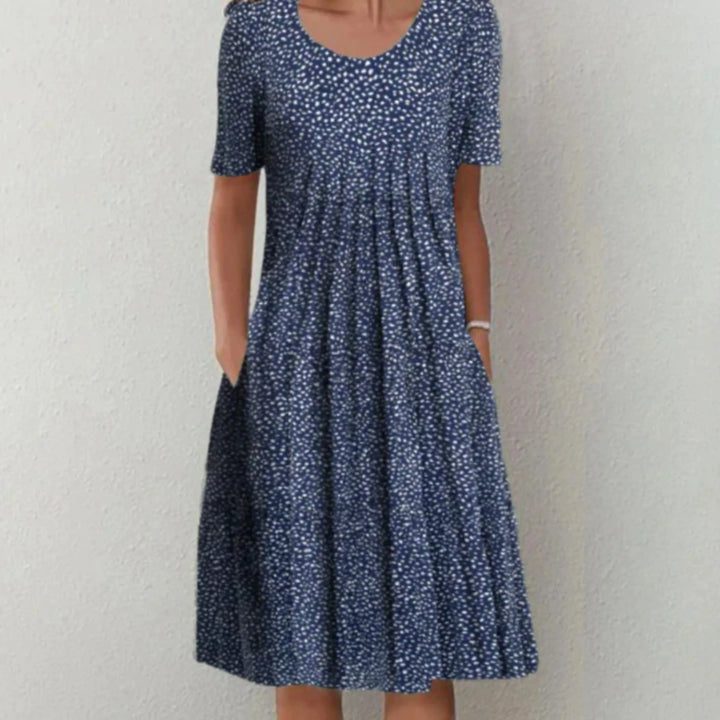 Robe à motifs floraux discrets, idéale pour un look chic et décontracté pendant l'été. Coupe fluide avec poches latérales, parfaite pour une silhouette féminine et élégante.