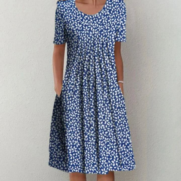 Robe d'été à motif floral bleu et blanc, avec une coupe fluide et féminine. Idéale pour un look frais et élégant, parfaite pour les journées estivales.
