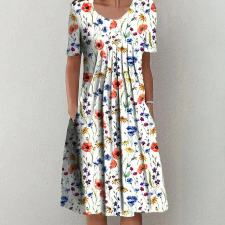 Robe d'été légère à motifs floraux vibrants, idéale pour un look coloré et féminin. Parfaite pour les journées chaudes, avec une coupe fluide et pratique grâce à ses poches latérales.