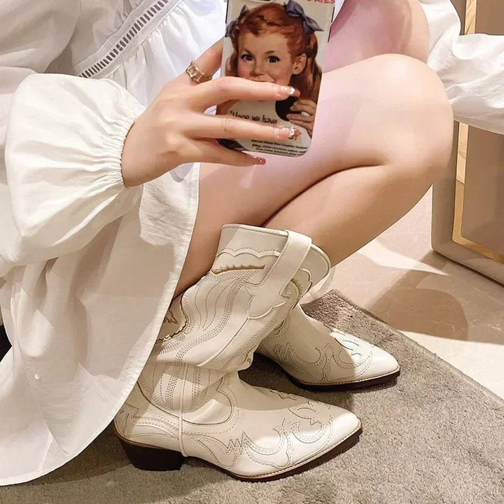 Bottes blanches de style cowboy, ornées de broderies fines et de détails délicats. La forme pointue du bout et le talon bas assurent un confort élégant. Une silhouette moderne et tendance, idéale pour compléter un look audacieux et raffiné.