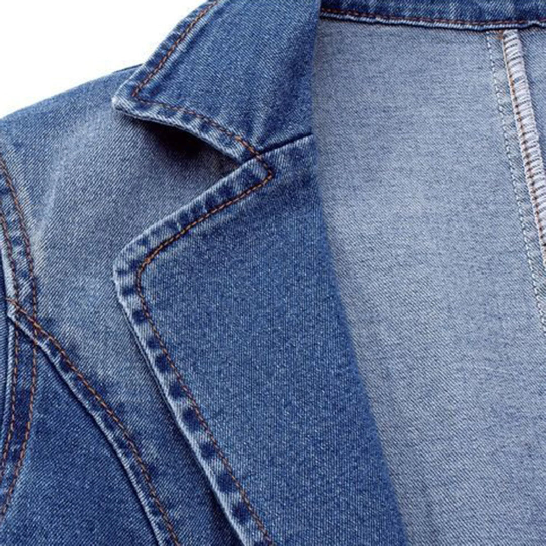 Détail du col du blazer en denim bleu, mettant en valeur sa coupe nette et ses coutures précises. Un design moderne et élégant pour un look à la fois chic et décontracté.