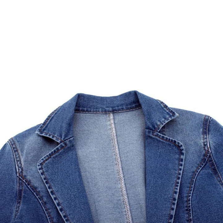 Détail du col du blazer en denim bleu, mettant en avant la coupe élégante et la finition soignée du vêtement, idéal pour un look à la fois moderne et décontracté.