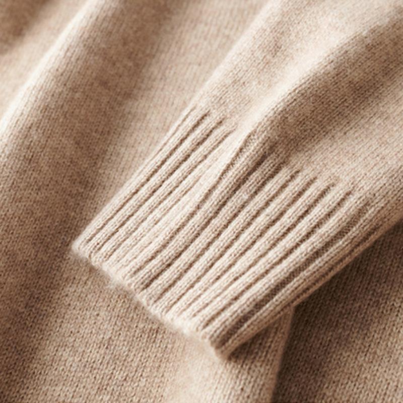 Détail d’un poignet côtelé sur un pull beige, montrant la finition tricotée et la texture douce de la matière.