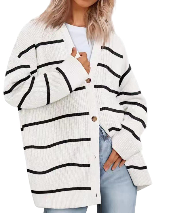 Femme portant un cardigan blanc à rayures noires, coupe oversize avec col en V et boutons en bois, superposé à un t-shirt blanc et assorti à un jean clair.