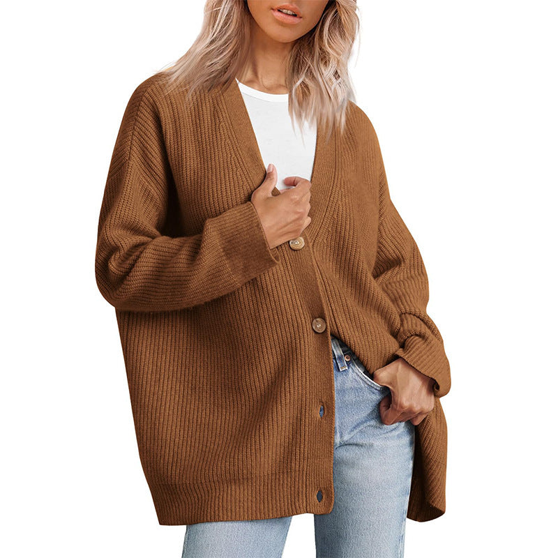 Femme portant un cardigan oversize marron à col en V, fermé par de gros boutons, superposé à un t-shirt blanc et associé à un jean clair.