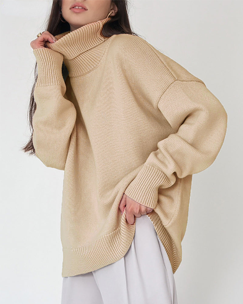 Une femme porte un pull à col roulé kaki oversize, dans un style à la fois décontracté et chic. Le tricot présente des bords-côtes au col, aux poignets et à l'ourlet, offrant une texture douce et confortable. Associé à un pantalon large clair, cet ensemble crée une allure moderne et élégante, idéale pour les journées d'hiver.