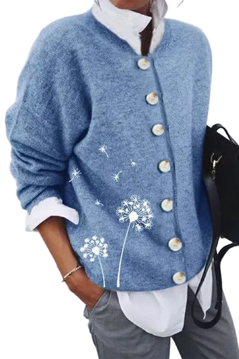 Cardigan bleu pour femme avec de grands boutons nacrés et un motif délicat de pissenlits blancs, porté sur une chemise blanche pour un look moderne, doux et décontracté.