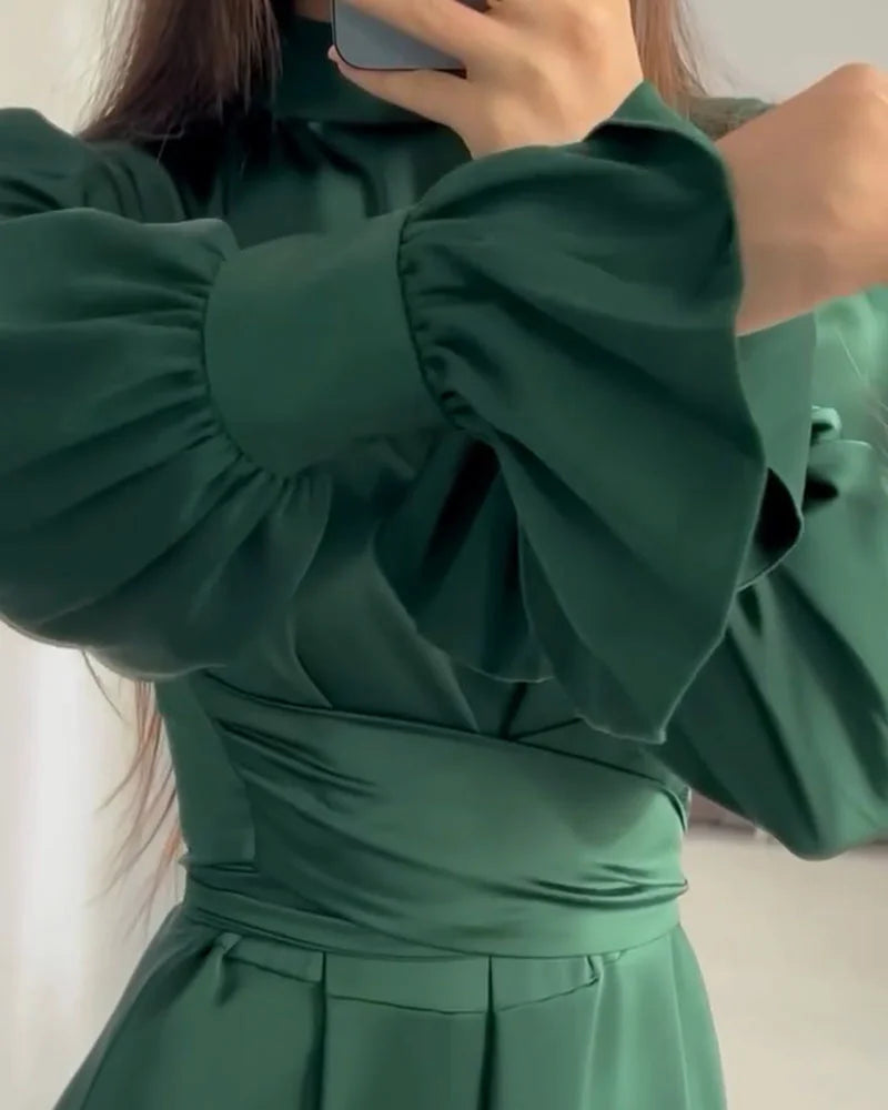 Gros plan sur la robe longue pour femme Aveline vert foncé, col montant, taille cintrée et manches bouffantes avec poignets froncés.