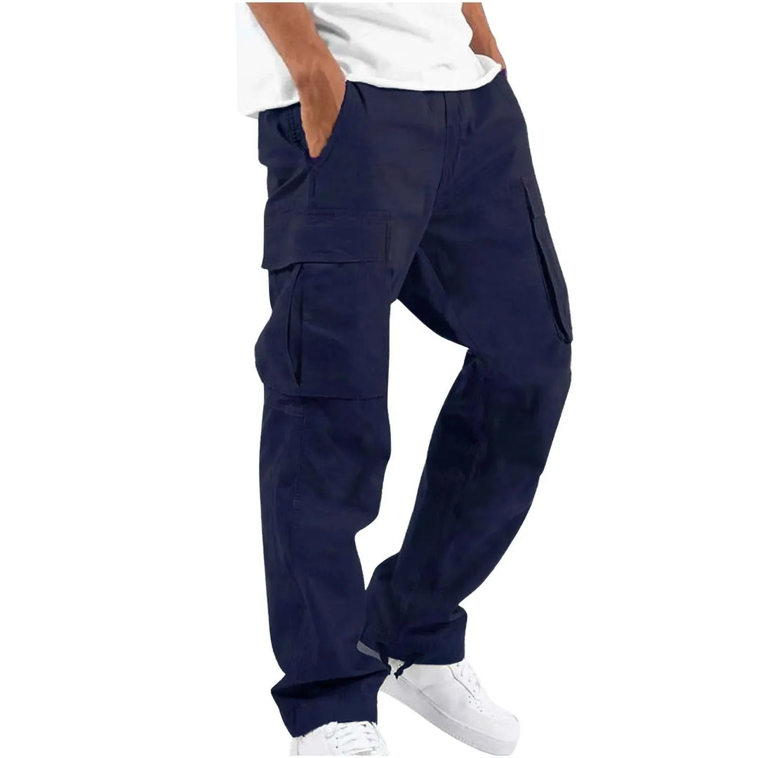 Homme portant le pantalon droit Aymeric pour hommes, style cargo bleu marine avec grandes poches latérales, coupe droite confortable et bas ajustables, porté avec un t-shirt blanc et des baskets blanches  look tendance et décontracté.