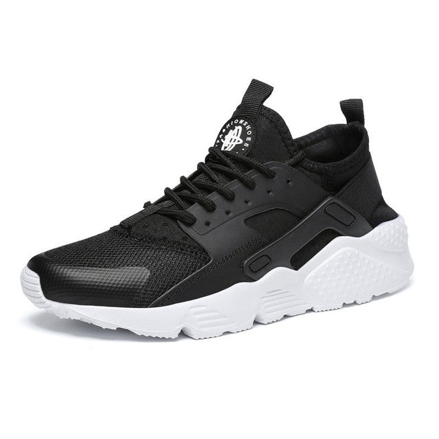 Sneaker noire en maille respirante avec lacets, renfort latéral et semelle épaisse blanche texturée, vue de profil sur fond blanc.