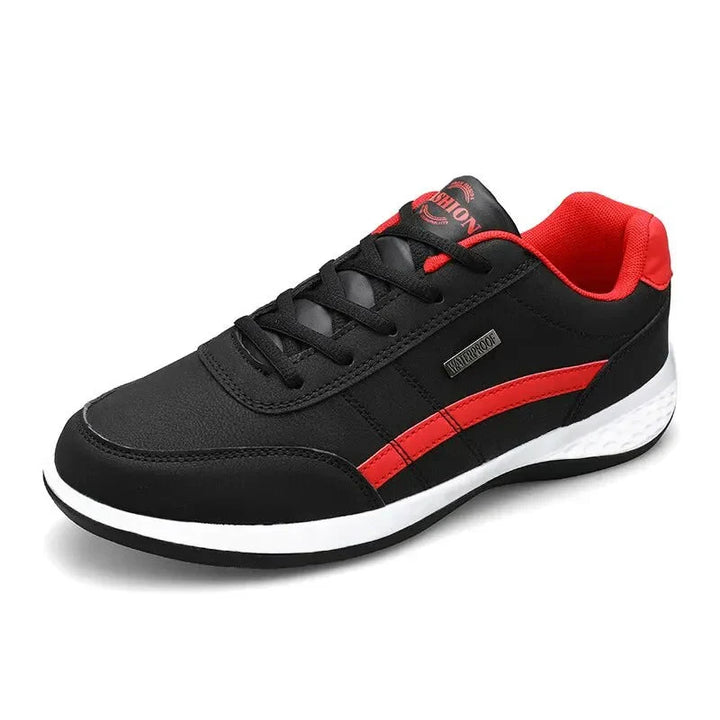 Chaussure décontractée Benoît pour homme en noir avec détails rouges, lacets noirs et semelle blanche amortissante, design moderne et confortable pour un look casual au quotidien.