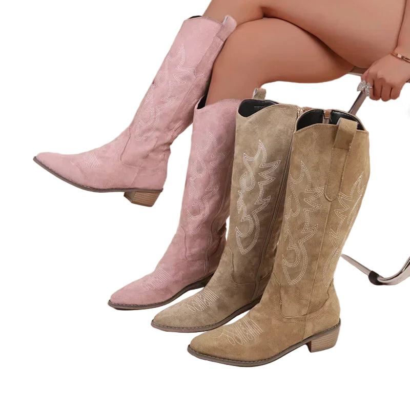 Bottes de cowboy pour femme, disponibles en rose et beige, avec des broderies décoratives sur la tige. Elles sont équipées de talons en bois et d'une forme pointue à l'avant, combinant style traditionnel et moderne.