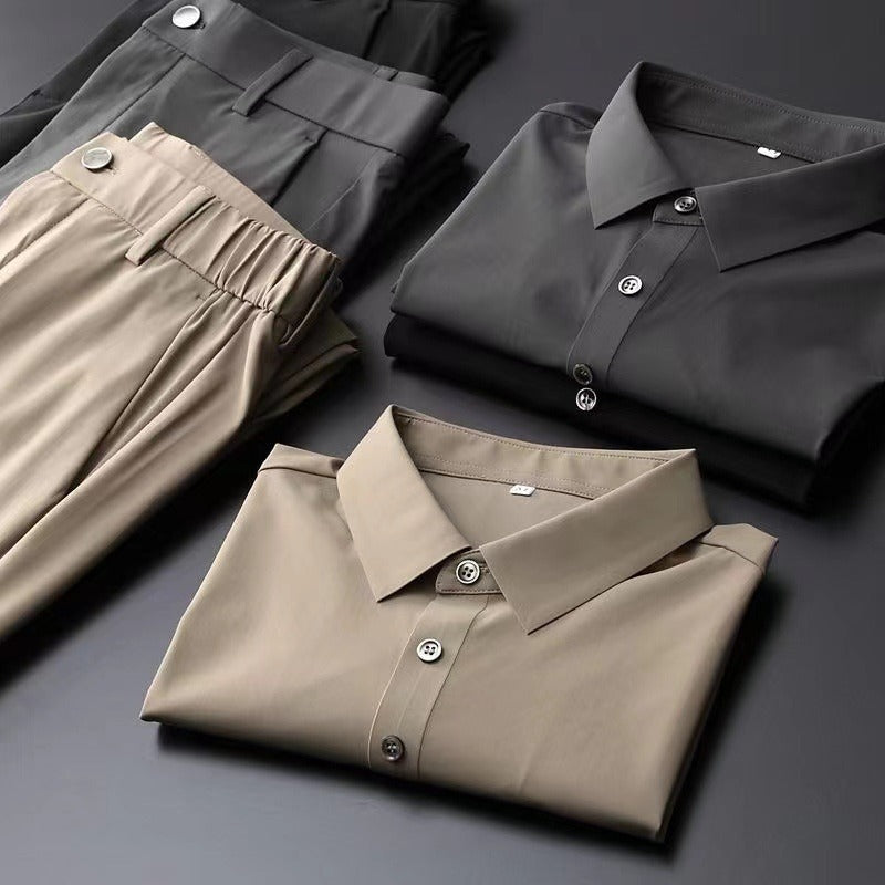 Ensemble d’été pour homme composé d’un pantalon beige et d’une chemise à manches courtes assortie, présenté plié à côté d’une version noire sur fond sombre.