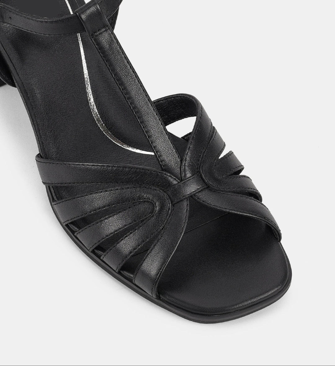 Vue rapprochée des sandales à bride cheville et talon bloc pour femmes. Détail des lanières croisées en cuir, offrant une coupe élégante et moderne avec un design soigné pour un confort optimal.