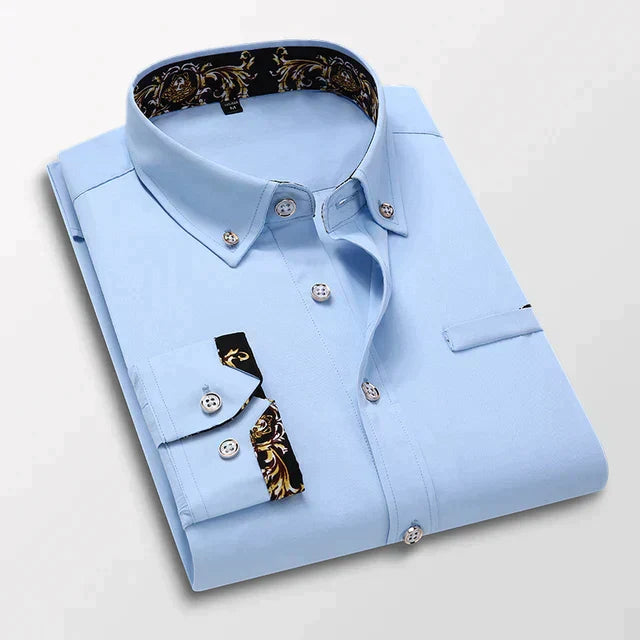 Chemise longue Bruno pour homme bleu ciel, col pointu et manches longues, pliée avec boutons contrastés et détails imprimés au col et aux poignets.