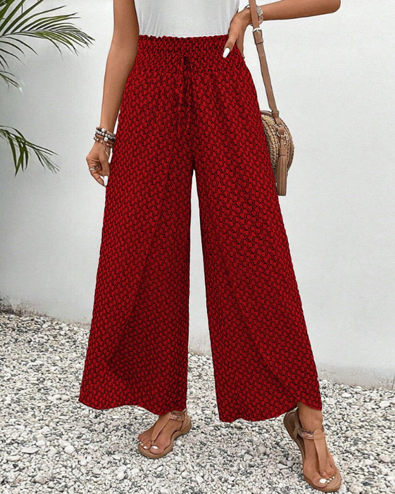 pantalon à coupe large avec taille élastiquée et motif géométrique rouge, parfait pour un look à la fois moderne et confortable. Idéal pour une tenue estivale décontractée.
