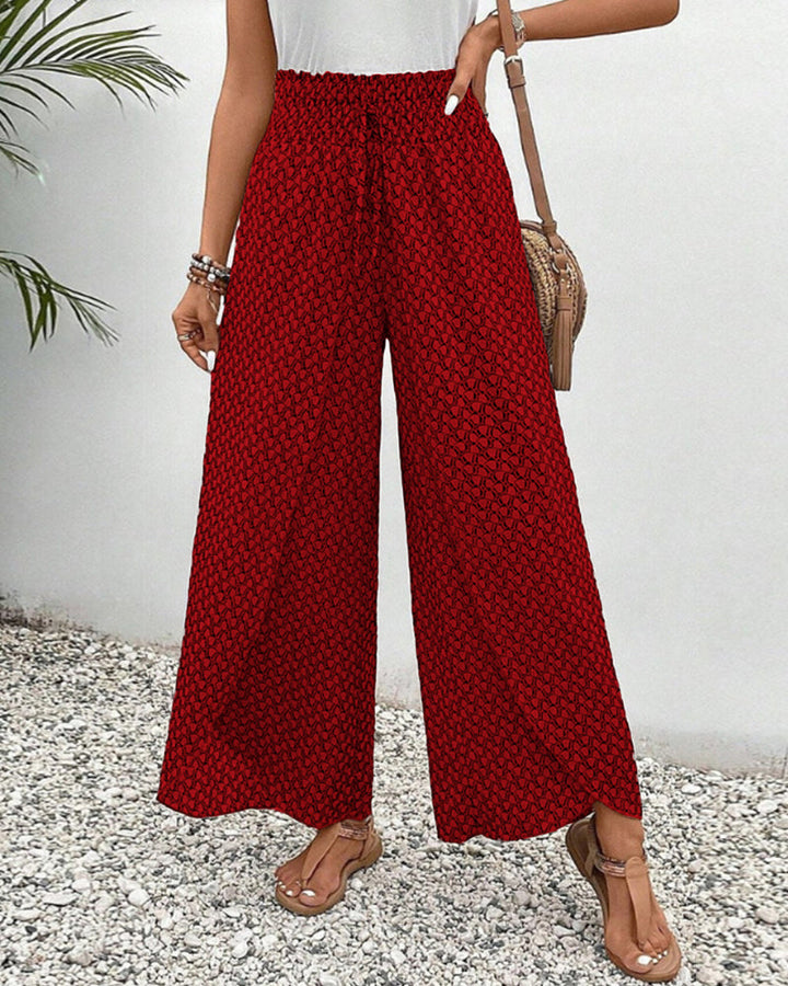 pantalon à coupe large avec taille élastiquée et motif géométrique rouge, parfait pour un look à la fois moderne et confortable. Idéal pour une tenue estivale décontractée.