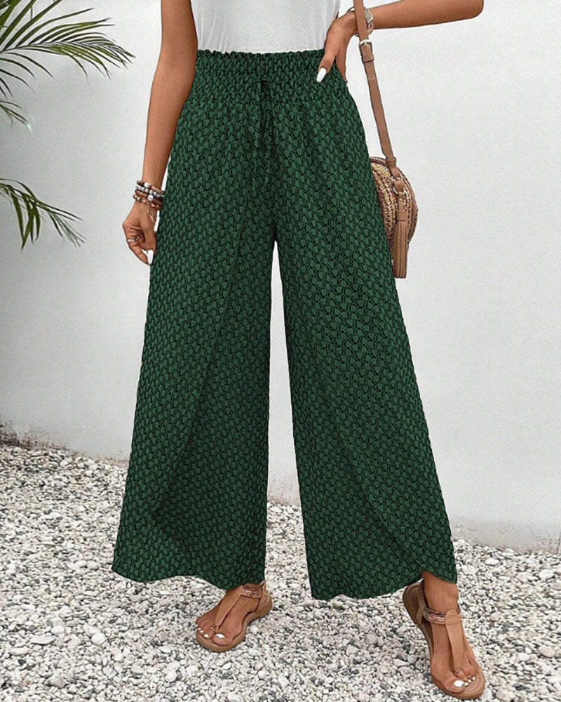 pantalon à coupe large avec taille élastiquée et motif géométrique vert, parfait pour un look moderne et estival. À porter avec un top léger pour une tenue décontractée et élégante.