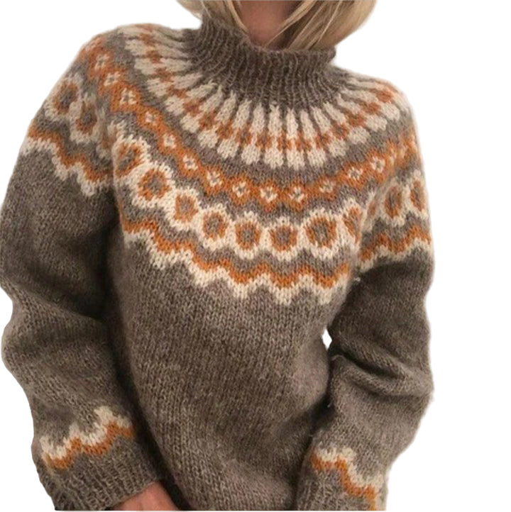 Une femme porte un pull kaki chaud et épais, orné de motifs nordiques blancs et orange sur le corsage et les manches. Ce vêtement d'hiver à col montant offre un style à la fois douillet et élégant, idéal pour affronter les journées froides avec confort et charme.