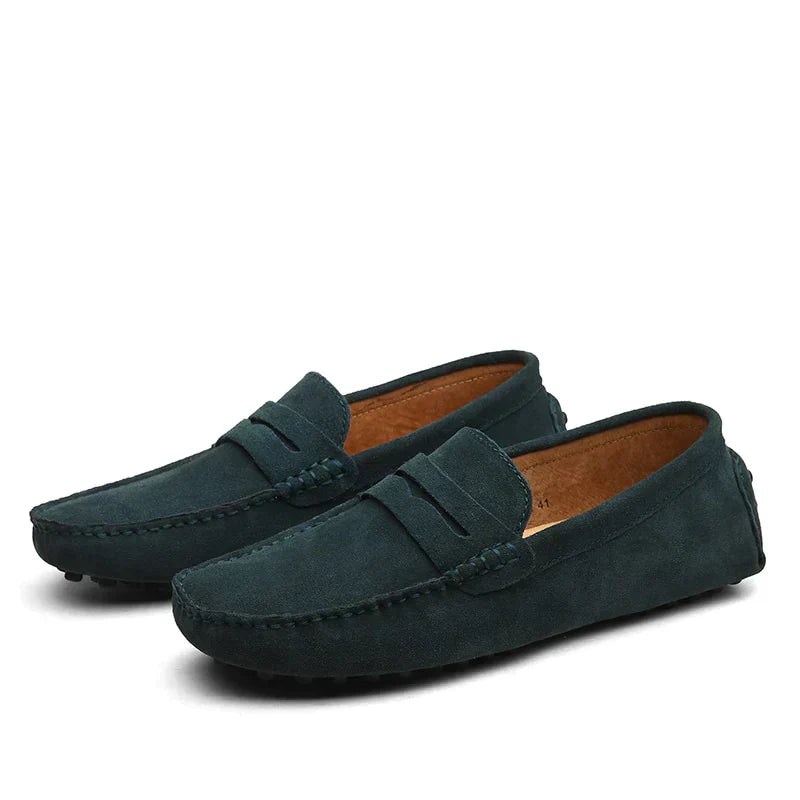 Une paire de mocassins en daim vert foncé, au style élégant et moderne. Parfaits pour un look décontracté et sophistiqué, ces mocassins sont idéals pour compléter vos tenues avec confort et classe.