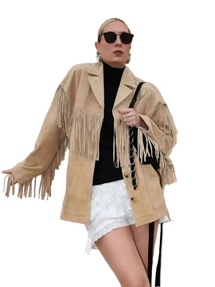 Veste à franges pour femme, modèle Charlène. Veste beige en suède avec franges élégantes sur les manches, portée avec un t-shirt noir et des shorts blancs. Un look chic et moderne, accessoirisé avec un sac à main noir. Parfait pour un style décontracté et tendance.