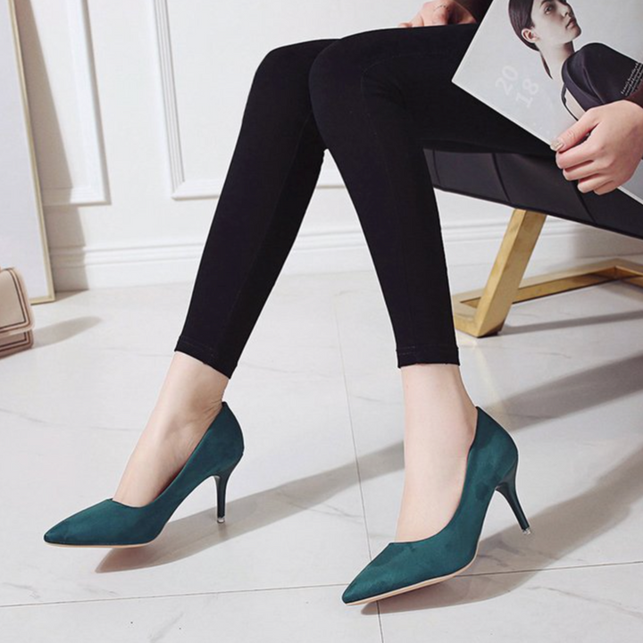 Escarpins vert canard effet suédine à bout pointu et talon fin, portés avec un legging noir, style chic et moderne pour une tenue élégante.