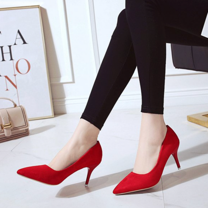 Escarpins rouges à bout pointu et talon fin, portés avec un legging noir, look élégant et audacieux pour une tenue chic.