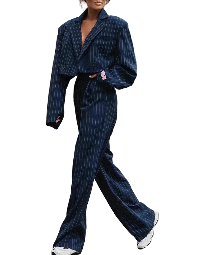 Ensemble pour femme Doriane tendance, costume bleu marine à fines rayures avec blazer oversize court et pantalon taille haute évasé, porté en ville avec des baskets blanches.
