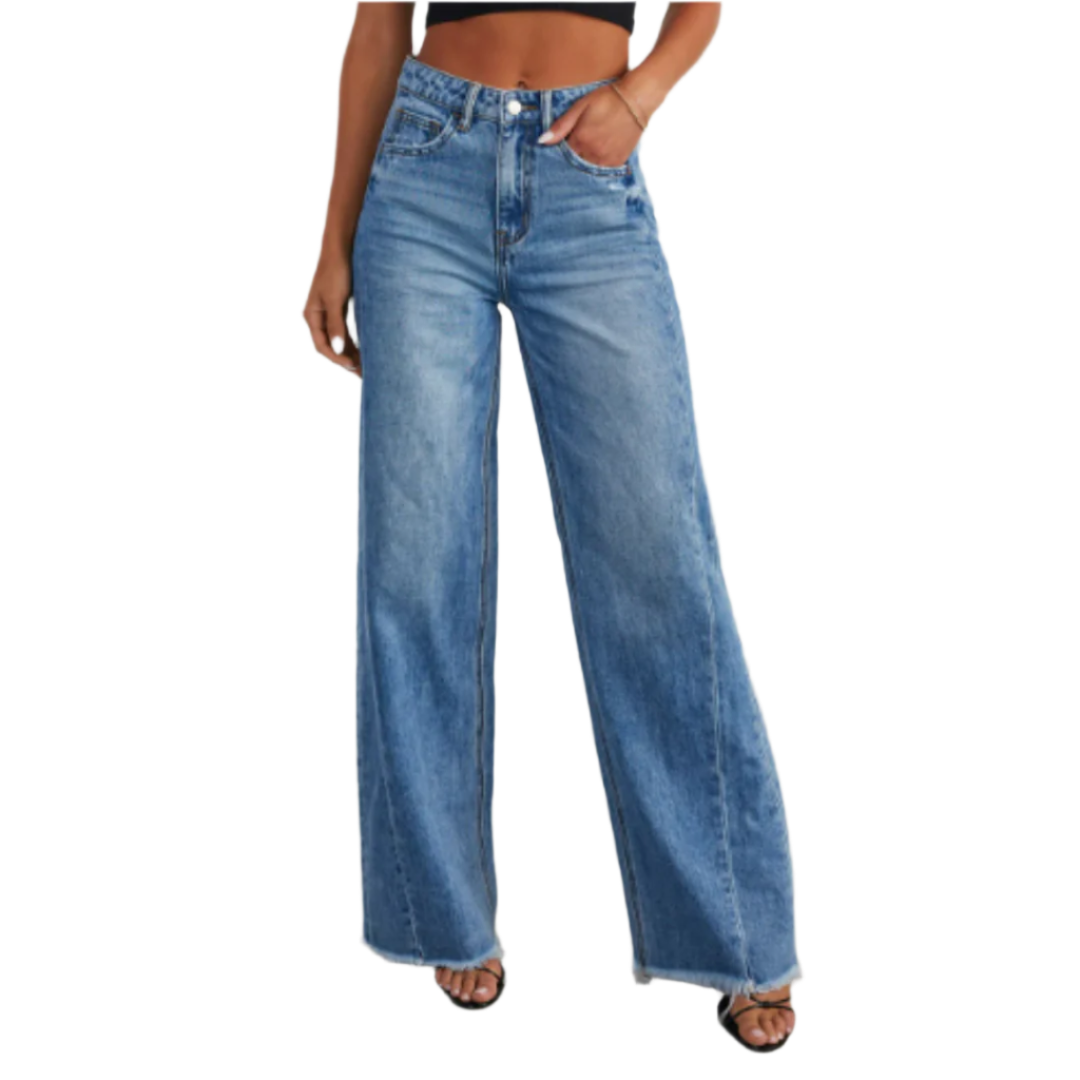 Pantalon taille haute femme Dorothée tendance, coupe large en jean bleu clair, avec bas effiloché, porté avec un crop top noir et des sandales à talons.