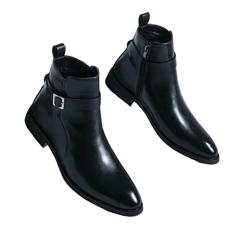 Paire de bottines noires en cuir lisse, bout effilé, fermeture éclair latérale et bride avec boucle à l’arrière, posées sur fond clair.