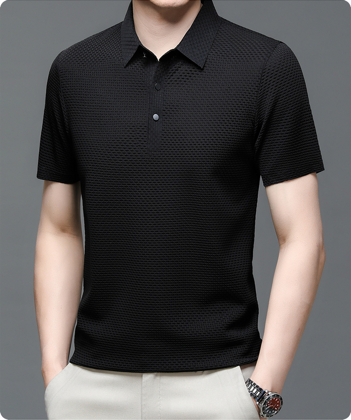 Un polo noir en maille texturée, avec un col classique et des boutons noirs contrastés. Ce modèle élégant et confortable est idéal pour un look moderne et décontracté, parfait pour toutes les occasions.