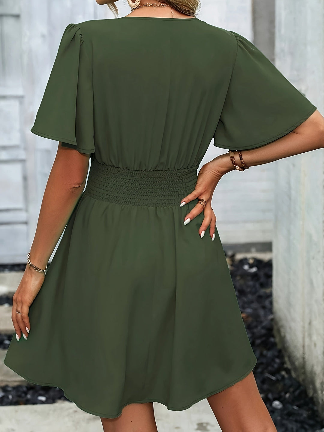 Vue de dos de la robe col V pour femme Elowen tendance, couleur vert kaki, manches courtes fluides et taille smockée, jupe évasée.