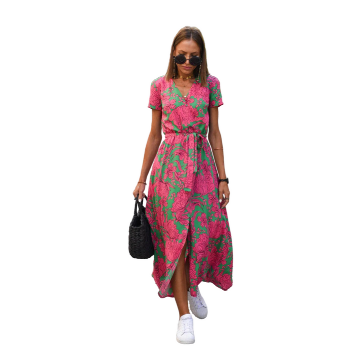 Robe décontractée Émeline pour femme, tendance et colorée. Ce modèle à imprimé floral vibrant avec des tons de rose et vert est parfait pour un look estival. Avec sa coupe fluide, sa taille élastiquée et sa fente élégante, cette robe est idéale pour un style décontracté tout en restant chic, à associer avec des baskets blanches pour une touche moderne.