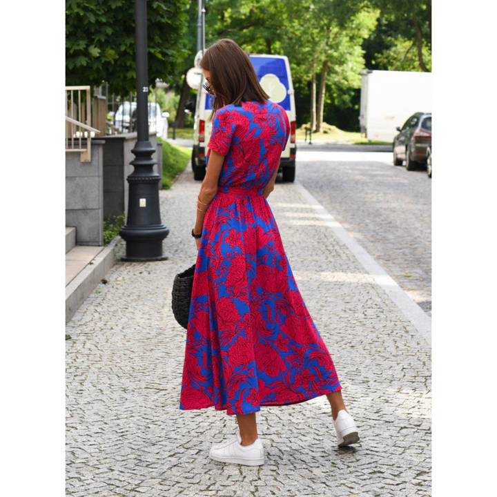 Robe décontractée Émeline pour femme, à imprimé floral vibrant dans des tons de rose et bleu. Avec sa coupe fluide et sa taille élastiquée, elle offre confort et style pour un look estival chic. Parfaite à porter avec des baskets pour un style décontracté ou des talons pour un look plus sophistiqué.