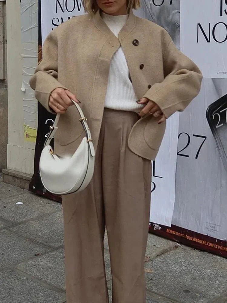 Veste courte pour femme Ethelyn, parfaite pour l'hiver. Ce modèle beige, avec ses boutons élégants et ses poches arrondies, offre un style chic et confortable. Portée avec un pull doux et un pantalon ample, cette veste apporte une touche sophistiquée à votre tenue tout en offrant chaleur et confort pour les journées fraîches.